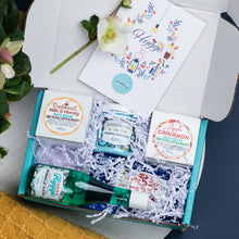 Load image into Gallery viewer, Open gift box with bath and body products and a card on a white surface.