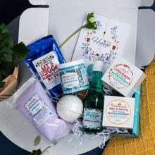 Load image into Gallery viewer, Bath and body products including a bottle, bath bomb, and soaps with &#39;Hygge&#39; branding on a white surface.