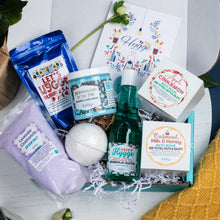 Load image into Gallery viewer, Bath and body products including a bottle of &#39;Happy Hygge&#39; bubble bath, a bath bomb, and various soaps in a box.