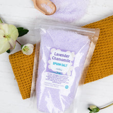 Load image into Gallery viewer, Packaged Lavender Chamomile Epsom Salt with a wooden scoop on a textured surface.