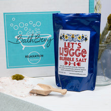 Load image into Gallery viewer, Bath bomb and bubble salt packaging on a surface with decorative elements.
