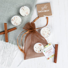 Load image into Gallery viewer, Bath bombs in a brown drawstring bag with &#39;Bath Bevy&#39; packaging on a textured surface.