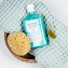 Load image into Gallery viewer, Pistachio Pumpkin body wash bottle with a sponge and dried plant on a textured fabric background