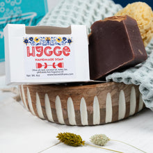 Load image into Gallery viewer, Handmade soap with a &#39;Hygge&#39; label in a wooden bowl on a textured surface.