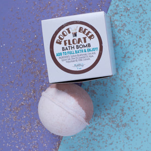 Root Beer Float bath bomb with packaging on a glittery blue and purple background