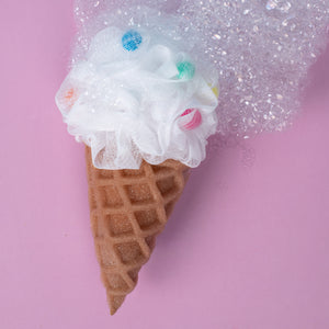 Ice cream cone with white fluffy top on a pink background