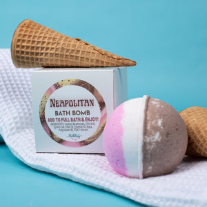 Neapolitan bath bomb with waffle cone and packaging on a blue background