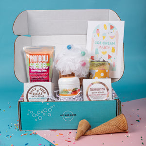 Box of bath products with a cone and sprinkles on a blue and pink background