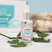 Load image into Gallery viewer, Hand sanitizer spray bottle with a floral label on a white surface with leaves.