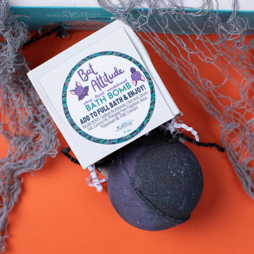 Bath bomb with packaging on an orange surface