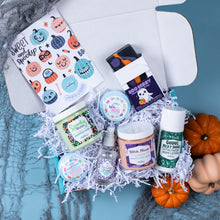 Load image into Gallery viewer, Halloween-themed gift set with various products on a textured surface.
