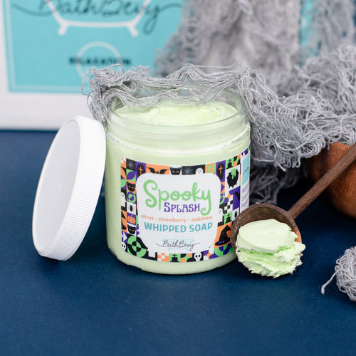 Spooky-themed whipped soap jar with a scoop of soap on a blue surface