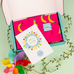 Open box with colorful greeting card and decorative items on a light green background