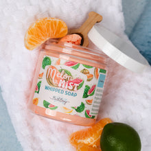 Load image into Gallery viewer, A jar of Bath Bevy Melon Mist Whipped Soap is styled on a white textured towel with citrus slices, including an orange slice, a lime, and a wooden scoop of the pink whipped soap inside.
