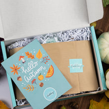 Load image into Gallery viewer, An open turquoise gift box with white crinkle paper filler, and a matching illustrated 'hello autumn' insert card.