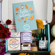 Load image into Gallery viewer, An autumn-themed bath gift box from Bath Bevy, featuring a light blue 'hello autumn' card, a lavender 'lavender Pajamas' whipped soap scrub jar, a 'Pumpkin Spice' bath bomb, and a bottle of happy hygge bubble bath, styled with fall leaves, pumpkins, and flowers.