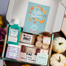 Load image into Gallery viewer, An autumn-themed self-care gift box from Tubless, filled with various bath and body products including Hygge Body Wash, Lavender Pajamas, and a Cozy Shower Steamers box, alongside a 'hello autumn' card and fall decorations.