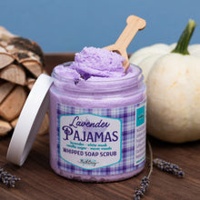 Load image into Gallery viewer, Lavender Pajamas whipped soap scrub in a clear jar with a purple label, shown with the lid off and a wooden scoop of the scrub on a rustic wooden surface with pumpkins and lavender sprigs.