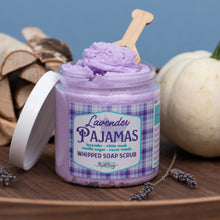 Load image into Gallery viewer, A jar of lavender whipped soap scrub sits on a wooden surface with the lid off, showing the purple scrub inside. The label reads 'Lavender Pajamas' and 'Whipped Soap Scrub' by Bath Bevy.