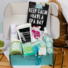 Load image into Gallery viewer, Spa day gift set with various items including bath bombs, eye pads, and a book titled 'Keep Calm and Have a Spa Day'.