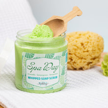 Load image into Gallery viewer, Jar of green whipped soap scrub with a wooden spoon and bath sponge on a white background