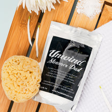 Load image into Gallery viewer, Unwind Steamers Dust packet with a sponge on a wooden surface with flowers.