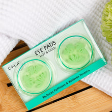 Load image into Gallery viewer, Calma eye pads packaging with green eye pads on a wooden surface with white towel and green flowers.