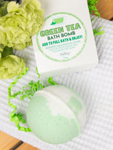 Load image into Gallery viewer, Green tea bath bomb with packaging on a textured surface with flowers.