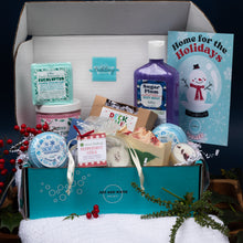Load image into Gallery viewer, Gifting box with various products including soap, body wash, and bath bombs on a snowy background.