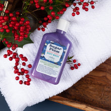 Load image into Gallery viewer, Purple bottle of Sugar Plum body wash on a white towel with red berries around