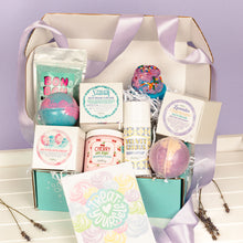 Load image into Gallery viewer, Gifting box with bath bombs, body lotion, and other products on a light purple background
