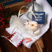 Load image into Gallery viewer, Candle with peppermint stick packaging and 'Bath Bevy' label on a wooden surface.