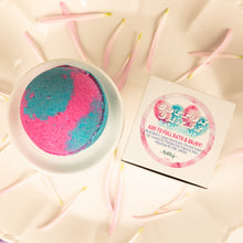 Load image into Gallery viewer, Bath bomb with pink and blue coloration on a decorative plate with a card.