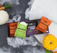 Load image into Gallery viewer, Three RAE brand shower steamers in colorful individually wrapped packets are arranged on top of a purple gift box. The packets are orange and green, labeled 'Pumpkins Cider Shower Steamer' and 'Ghostly Hollow Shower Steamer,' with the central packet open to show a white round steamer.