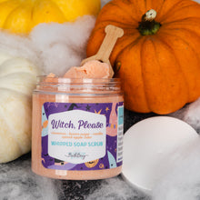 Load image into Gallery viewer, A jar of 'Witch, Please' whipped soap scrub by Bath Bevy, styled with orange and white pumpkins, white faux cobwebbing, and a wooden scoop on a dark gray background.
