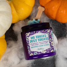 Load image into Gallery viewer, A jar of whipped soap scrub labeled 'No Tricks Just Treats' by Bath Bevy styled with pumpkins and white faux fur on a dark surface.