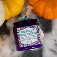 Load image into Gallery viewer, A jar of whipped soap scrub labeled 'No Tricks Just Treats' by Bath Bevy styled with pumpkins and white faux fur on a dark surface.