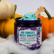 Load image into Gallery viewer, A jar of whipped soap scrub by Bath bevy sits on white faux fur with a bone-shaped wooden spoon, surrounded by pumpkins and cotton candy. The label reads 'NO TRICKS JUST TREATS'.