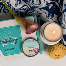 Load image into Gallery viewer, Bath and body products including a candle, calla lily, and bath items on a white surface with a blue and white patterned towel.