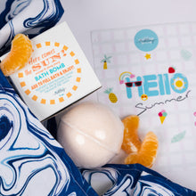 Load image into Gallery viewer, Bath bomb with packaging and orange slices on a 'Hello Summer' themed towel