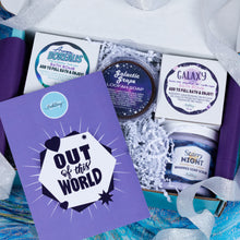Load image into Gallery viewer, A curated bath gift box from Bath Bevy, featuring a purple 'Out of this World' card, a jar of Galactic Grape loofah soap, a box with a Galaxy bath bomb, a box with an Aurora Boreaus bath bomb, a jar of Starry Night whipped soap scrub, and purple bath bombs inside white tissue paper.