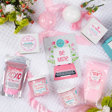 Load image into Gallery viewer, Collection of pink-themed products and packaging on a white surface with flowers.