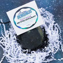Load image into Gallery viewer, A bath bomb product shot showing a dark green spherical bath bomb nestled in white shredded paper, with a branded insert card reading Aurora Borealis Bath Bomb.