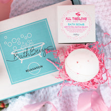Load image into Gallery viewer, Bath bomb with packaging and decorative elements on a soft surface