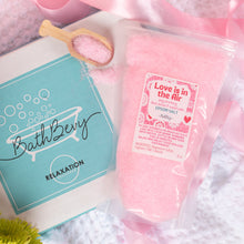 Load image into Gallery viewer, Pink bath bomb with packaging labeled 'BathBerry' and 'Love is in the Air' on a soft pink background.