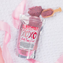 Load image into Gallery viewer, Bath fizzy dust packaging with pink powder and wooden scoop on a textured white background
